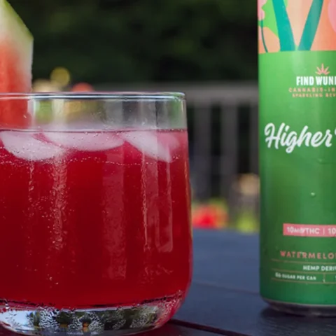 A Wunder Watermelon Basil can beside a glass of watermelon basil drink with a watermelon wedge