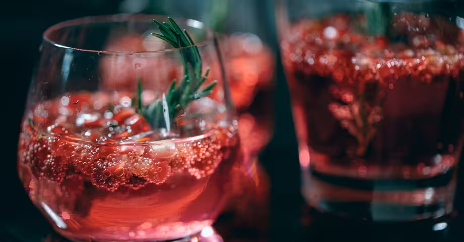 glasses of cranberry fizz garnished with cranberries and rosemary sprigs