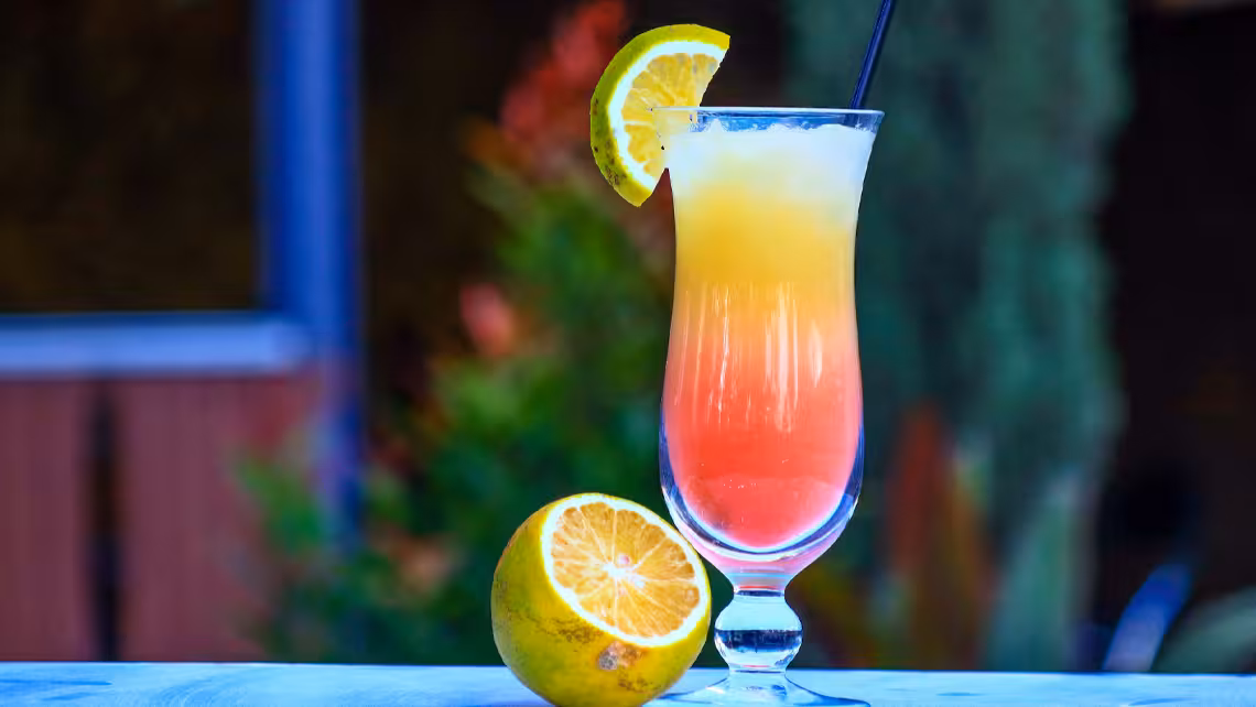 glass of San Francisco bubbly mocktail garnished with a lime wedge beside a sliced lime