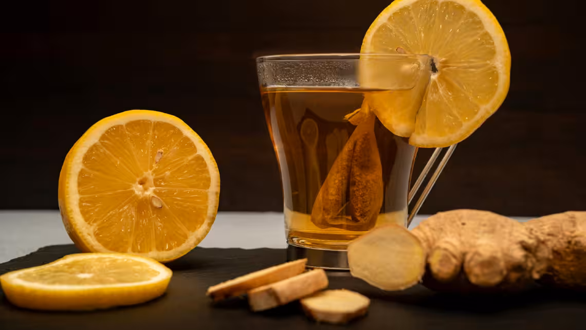 glass of sparkling ginger ale surrounded by ginger and lemon slices